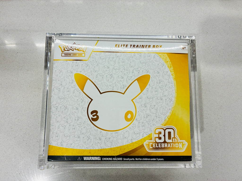 Actual Pokémon TCG 30th Celebration Elite Trainer Box with the included acrylic display case photographed on a light surface