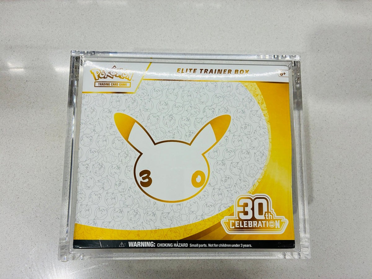 Actual Pokémon TCG 30th Celebration Elite Trainer Box with the included acrylic display case photographed on a light surface